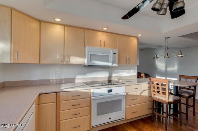 kitchen featuring dark hardwood / wood-style floors, light brown cabinets, hanging light fixtures, and white appliances