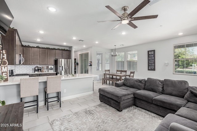 2640 N Heritage St, Buckeye, AZ 85396 - living area featuring light tile patterned flooring, recessed lighting, ceiling fan with notable chandelier, and plenty of natural light