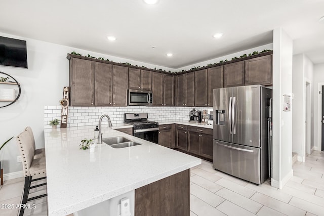 2640 N Heritage St, Buckeye, AZ 85396 - kitchen with a sink, light stone counters, a peninsula, dark brown cabinets, and appliances with stainless steel finishes