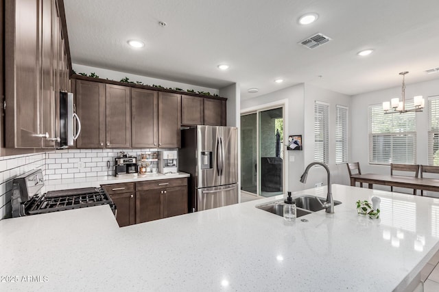 2640 N Heritage St, Buckeye, AZ 85396 - kitchen with a notable chandelier, dark brown cabinetry, a sink, appliances with stainless steel finishes, and visible vents