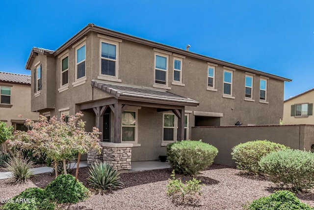 2640 N Heritage St, Buckeye, AZ 85396 - view of front facade featuring a tile roof, stucco siding, fence, and stone siding