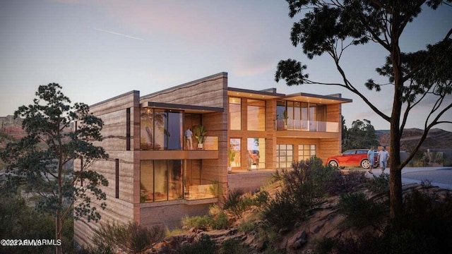 back house at dusk with a balcony