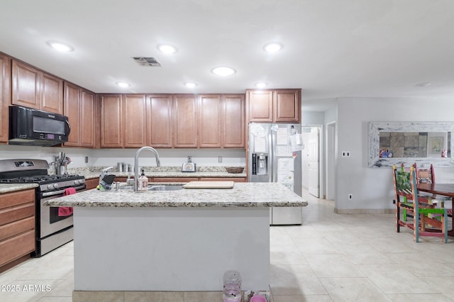 kitchen featuring visible vents, appliances with stainless steel finishes, a kitchen island with sink, a sink, and recessed lighting