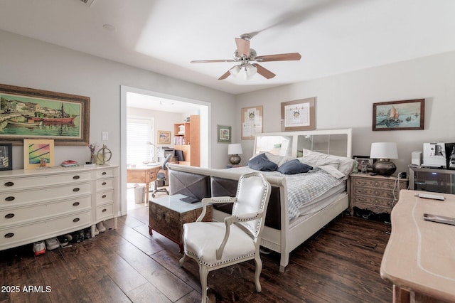 bedroom featuring ensuite bath, dark wood finished floors, and a ceiling fan