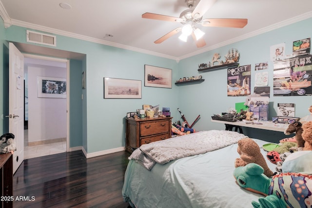 bedroom featuring baseboards, wood finished floors, visible vents, and crown molding