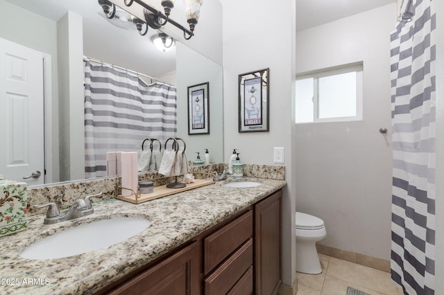 bathroom featuring tile patterned flooring, a sink, toilet, and double vanity