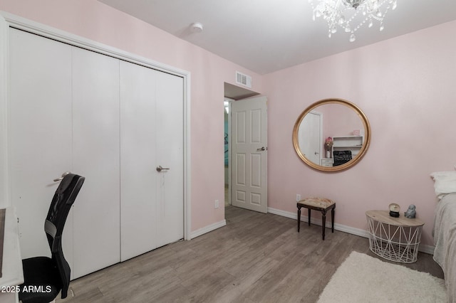 office featuring baseboards, visible vents, a chandelier, and wood finished floors