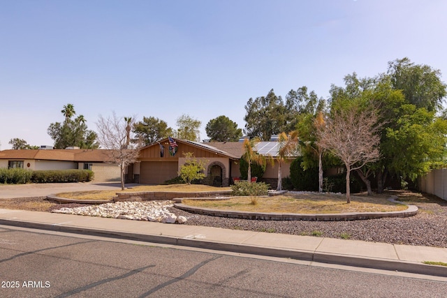 ranch-style home featuring a garage, concrete driveway, and solar panels