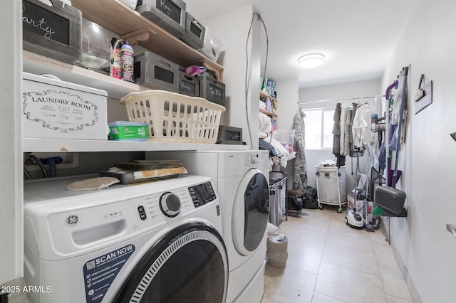 clothes washing area featuring laundry area, washing machine and clothes dryer, and tile patterned floors