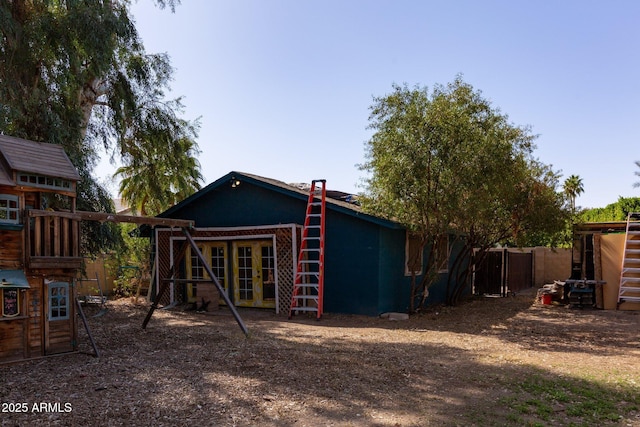 view of outbuilding with fence and a playground