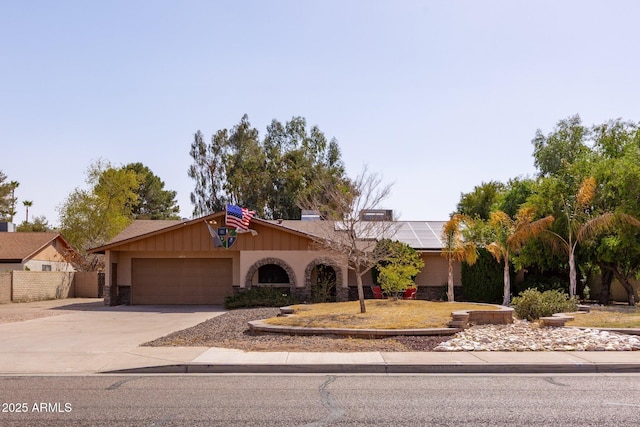 ranch-style house featuring driveway, an attached garage, and fence