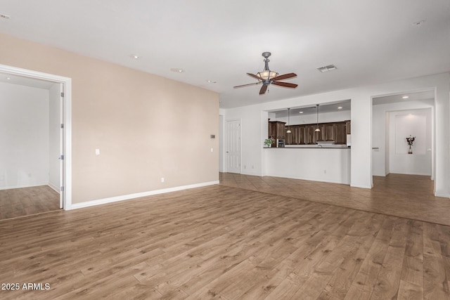 unfurnished living room featuring ceiling fan and light hardwood / wood-style flooring