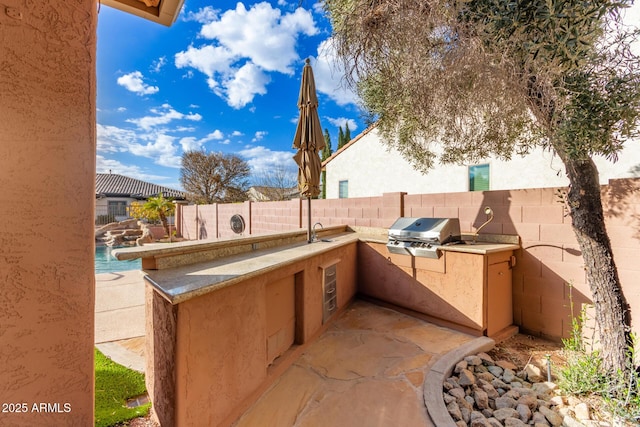 view of patio with sink, an outdoor kitchen, and area for grilling