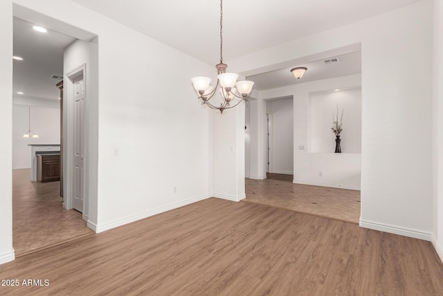 unfurnished room featuring wood-type flooring and a chandelier