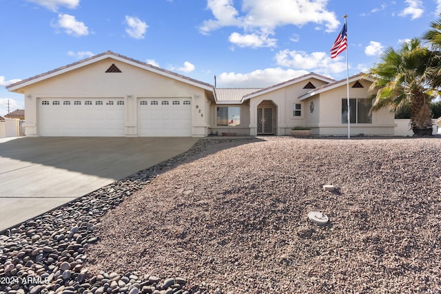 ranch-style house featuring a garage, driveway, a tiled roof, and stucco siding