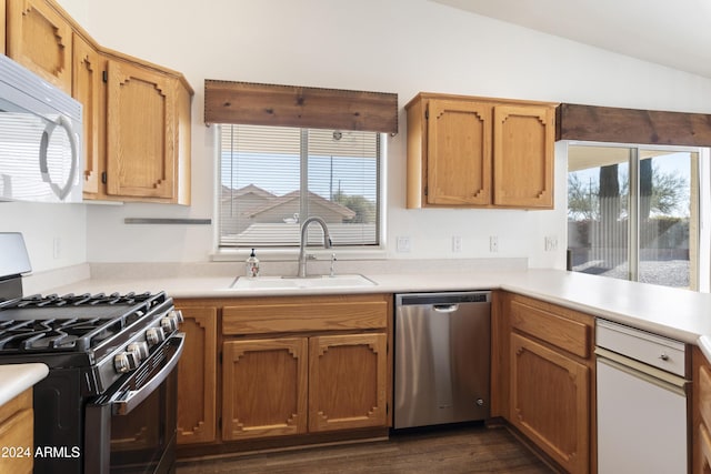 kitchen featuring white microwave, a sink, light countertops, stainless steel dishwasher, and gas range