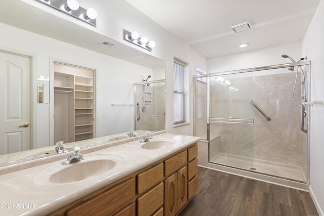 bathroom with a shower stall, visible vents, a sink, and wood finished floors