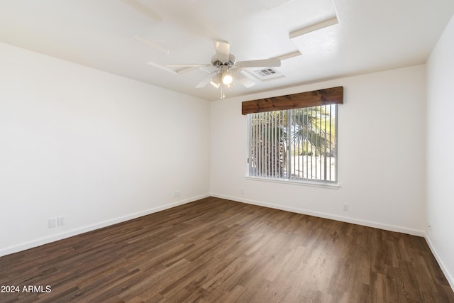 unfurnished room featuring dark wood-style floors, visible vents, ceiling fan, and baseboards