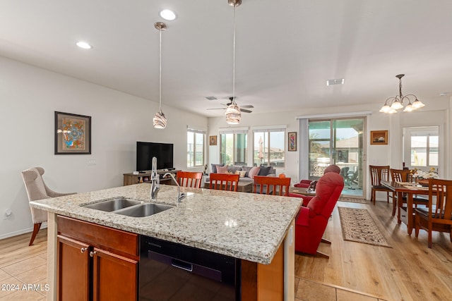 kitchen with ceiling fan with notable chandelier, black dishwasher, light hardwood / wood-style flooring, and an island with sink