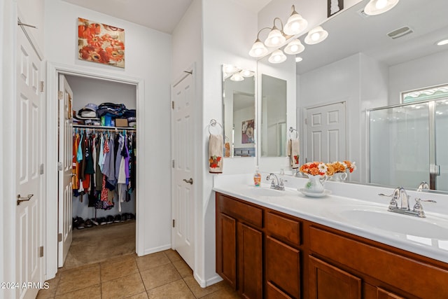 bathroom featuring vanity, a shower with shower door, and tile patterned floors