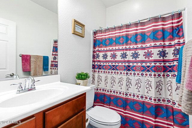 bathroom with vanity, toilet, and curtained shower