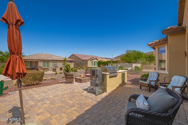 17540 W Glenhaven Dr, Goodyear, AZ 85338 - view of patio featuring a grill, an outdoor kitchen, and fence