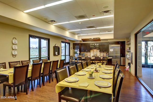 dining space with a paneled ceiling and dark hardwood / wood-style floors