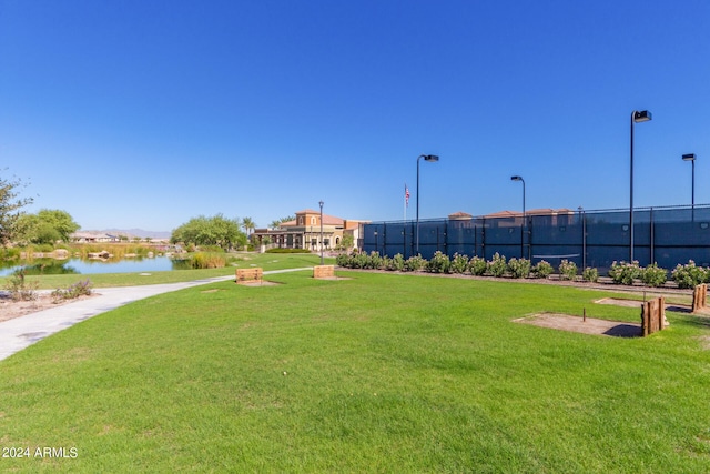 view of property's community with a lawn and a water view