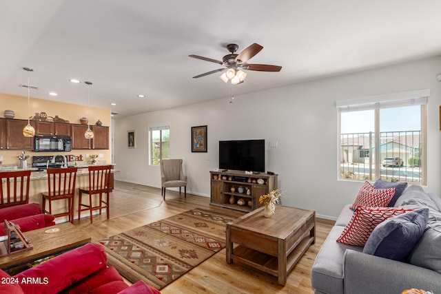 living room featuring ceiling fan and light hardwood / wood-style floors