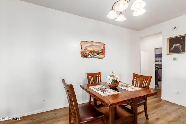 dining room featuring wood-type flooring and a notable chandelier