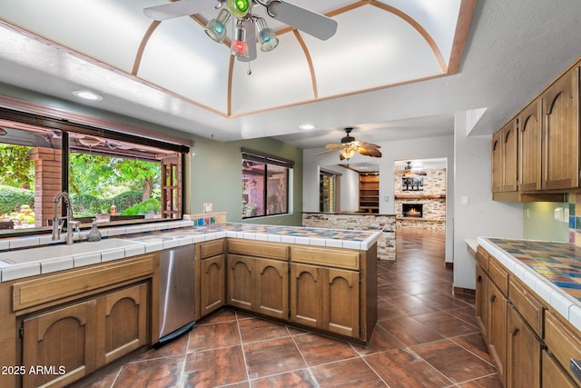 kitchen with a ceiling fan, a sink, healthy amount of natural light, tile counters, and recessed lighting