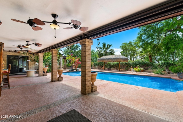 view of pool featuring a patio area, ceiling fan, and a fenced backyard