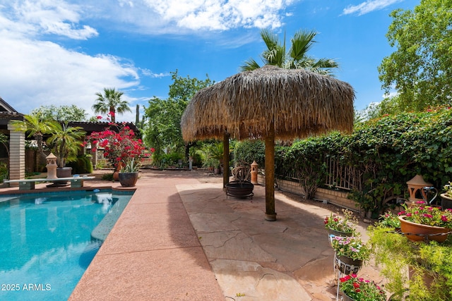 outdoor pool featuring a patio, a diving board, and fence
