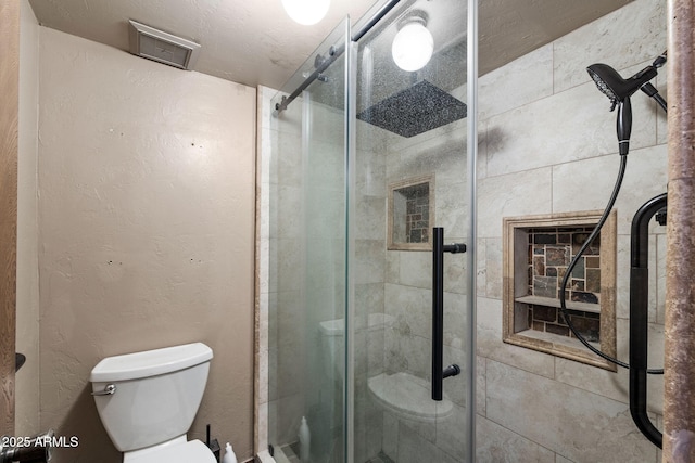 bathroom with toilet and a stall shower