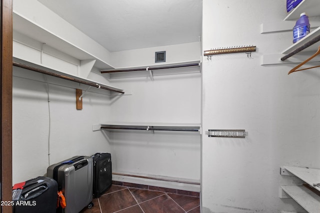 walk in closet with dark tile patterned floors
