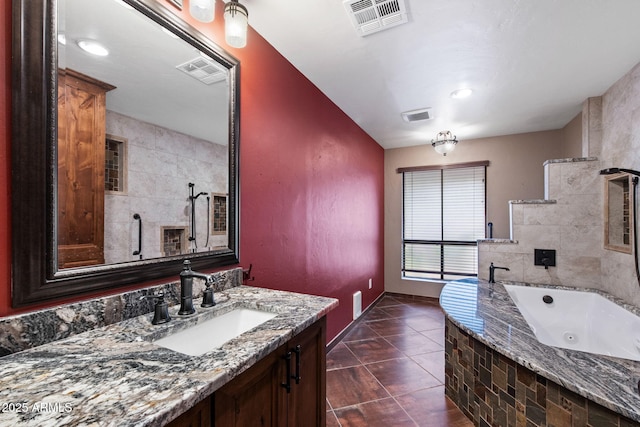 bathroom with a whirlpool tub, vanity, tile patterned flooring, and baseboards