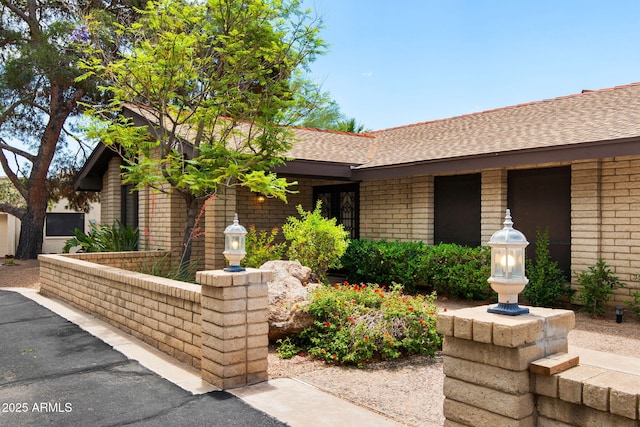 single story home with brick siding and a shingled roof