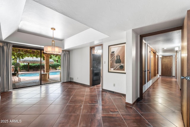 empty room with dark tile patterned floors, baseboards, and french doors
