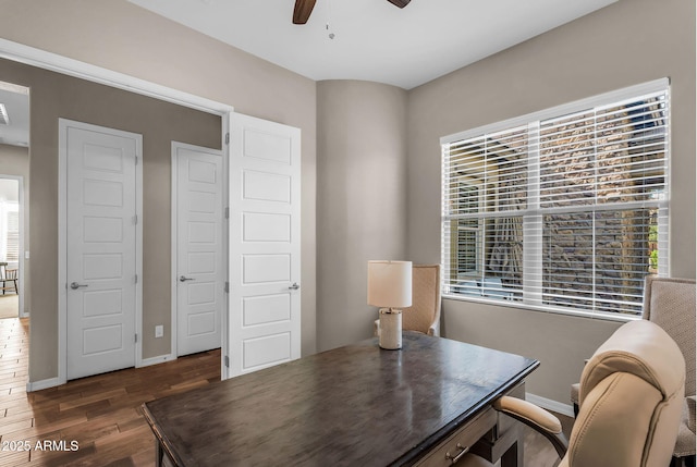 office area featuring a ceiling fan, baseboards, a healthy amount of sunlight, and wood finished floors