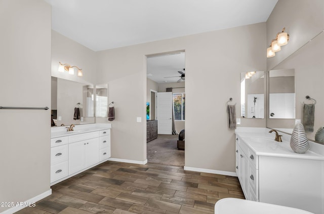 full bath featuring ceiling fan, two vanities, a sink, and wood finished floors