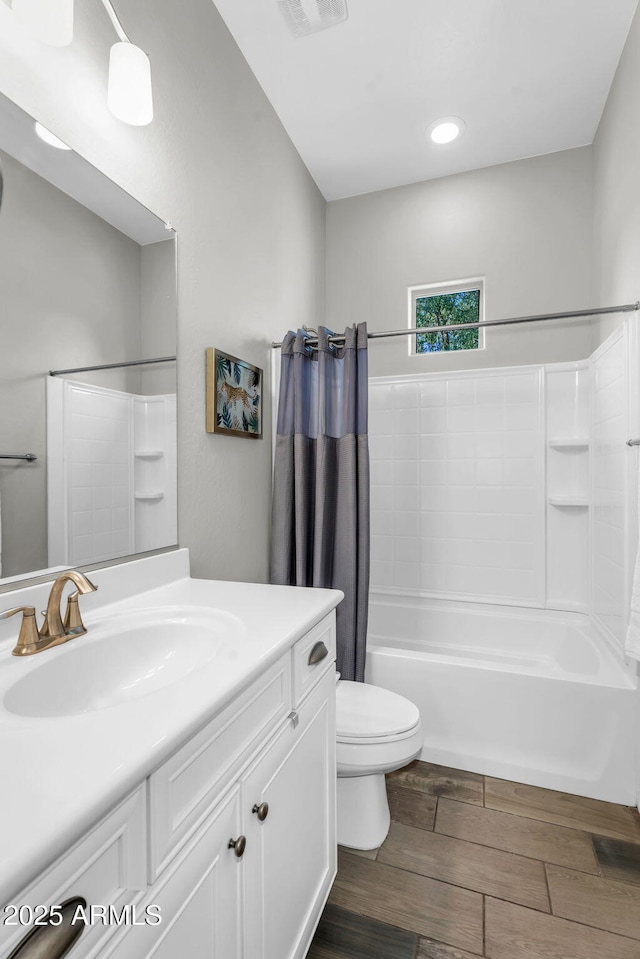 bathroom with shower / bath combo, vanity, toilet, wood finished floors, and visible vents