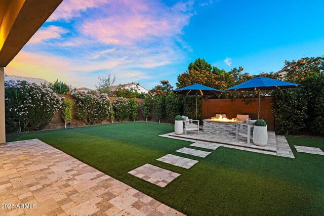 view of yard featuring a fenced backyard, a patio, and a fire pit