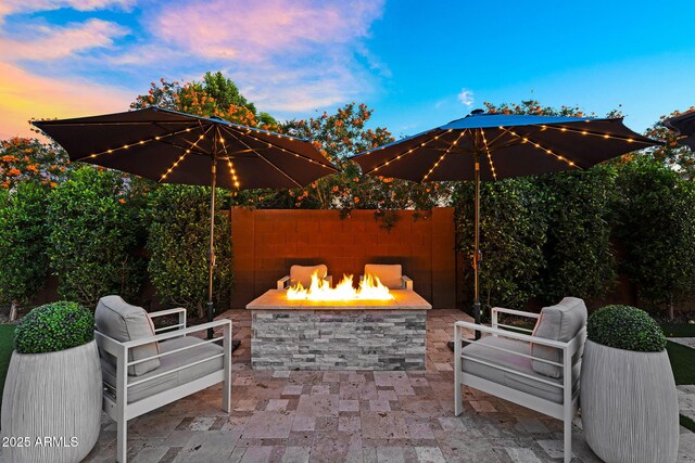 patio terrace at dusk featuring a fire pit
