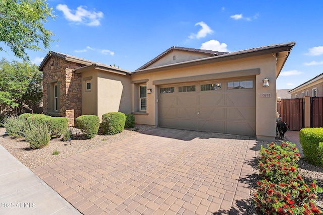 ranch-style house with a garage, decorative driveway, stucco siding, and stone siding