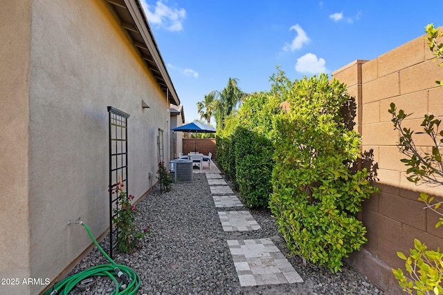 exterior space featuring a fenced backyard, a patio area, and central AC unit