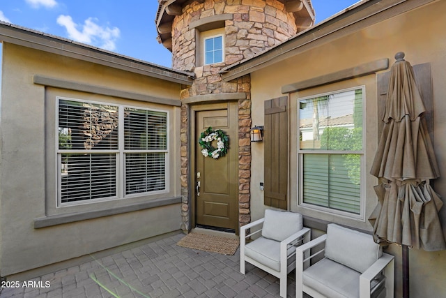entrance to property with stucco siding and stone siding