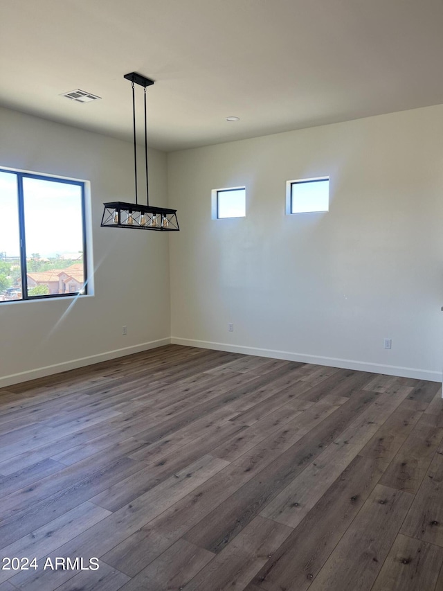 unfurnished dining area featuring plenty of natural light and dark wood-type flooring