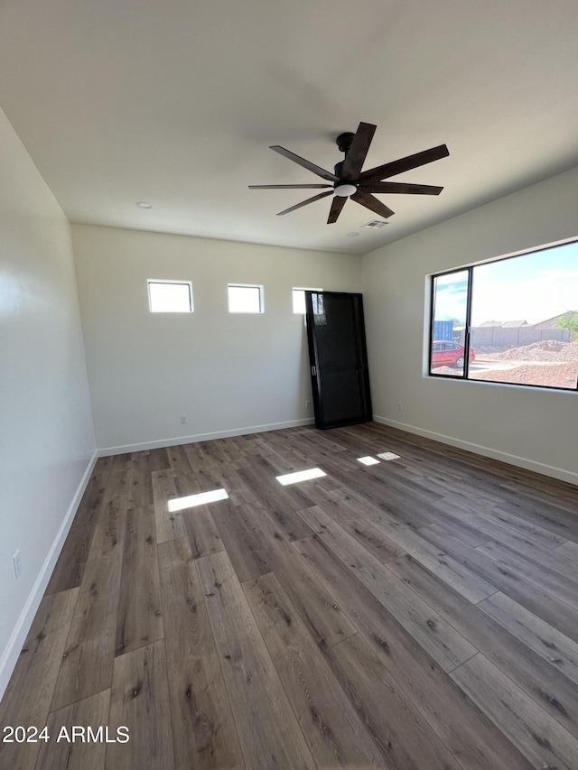 empty room with hardwood / wood-style flooring and ceiling fan