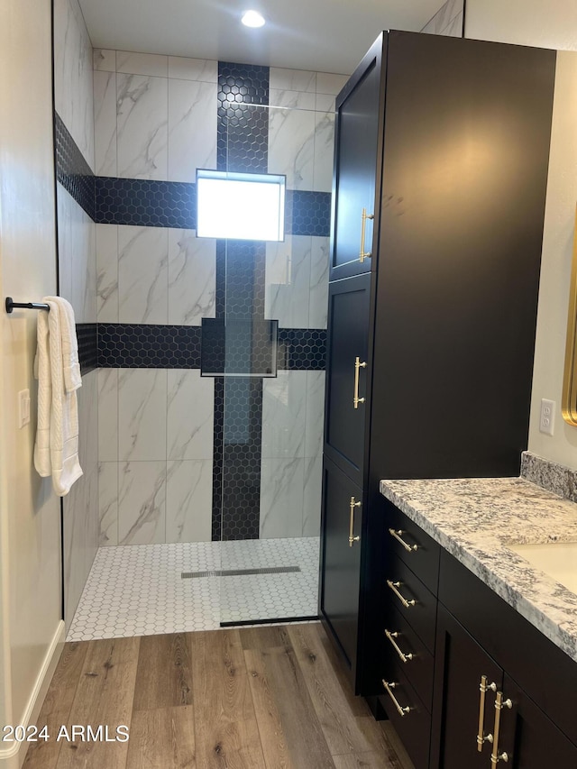 bathroom featuring vanity, wood-type flooring, and a shower with shower door