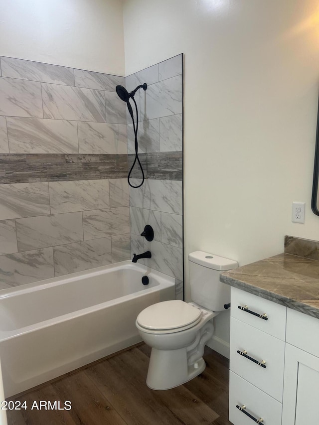 full bathroom with vanity, toilet, wood-type flooring, and tiled shower / bath